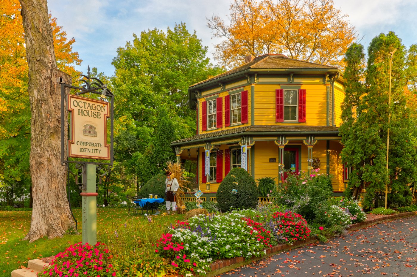 Front exterior of a white multi-story house with a covered porch, lawn, shrubs, and mature trees in Barrington, Illinois.