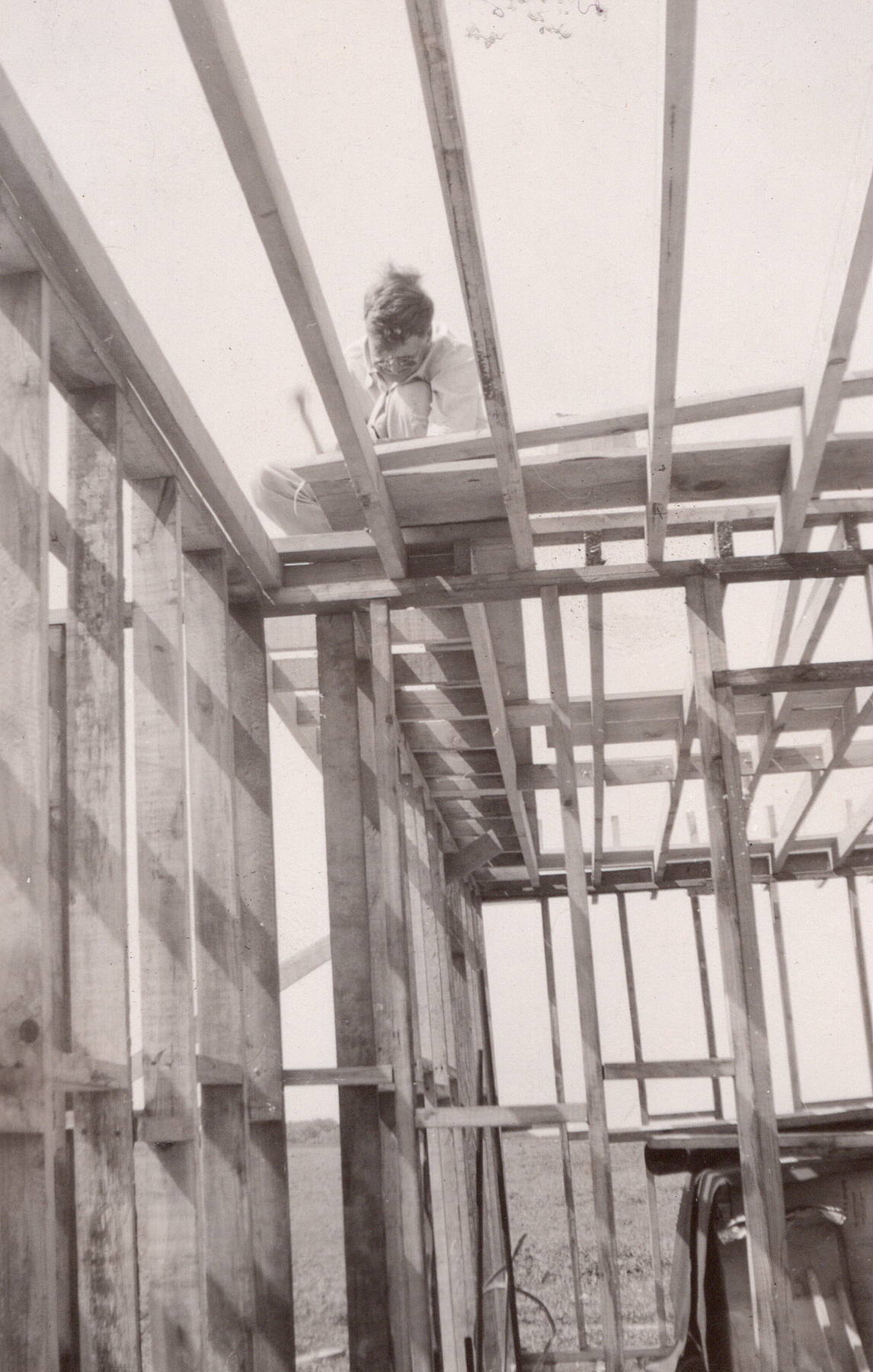 Worker standing inside the unfinished wood framing of a single-family house under construction in Lockport, Illinois, in 1947.
