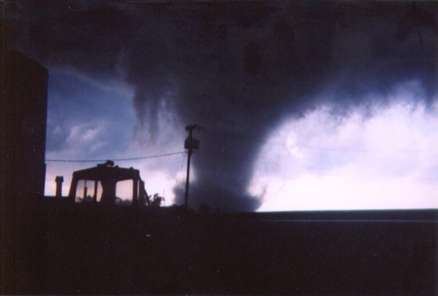 A large tornado funnel crossing open farmland, viewed from a safe distance west of Roanoke, Illinois.